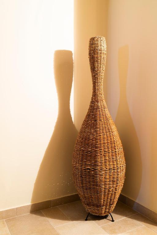 a wicker vase sitting next to a wall at Flash House in Spetses