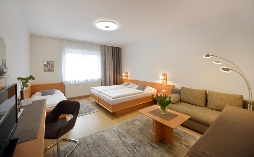 ein großes Wohnzimmer mit einem Sofa und einem Bett in der Unterkunft NATIONALPARKHOF GARTNER Weingut-Gästehaus in Illmitz