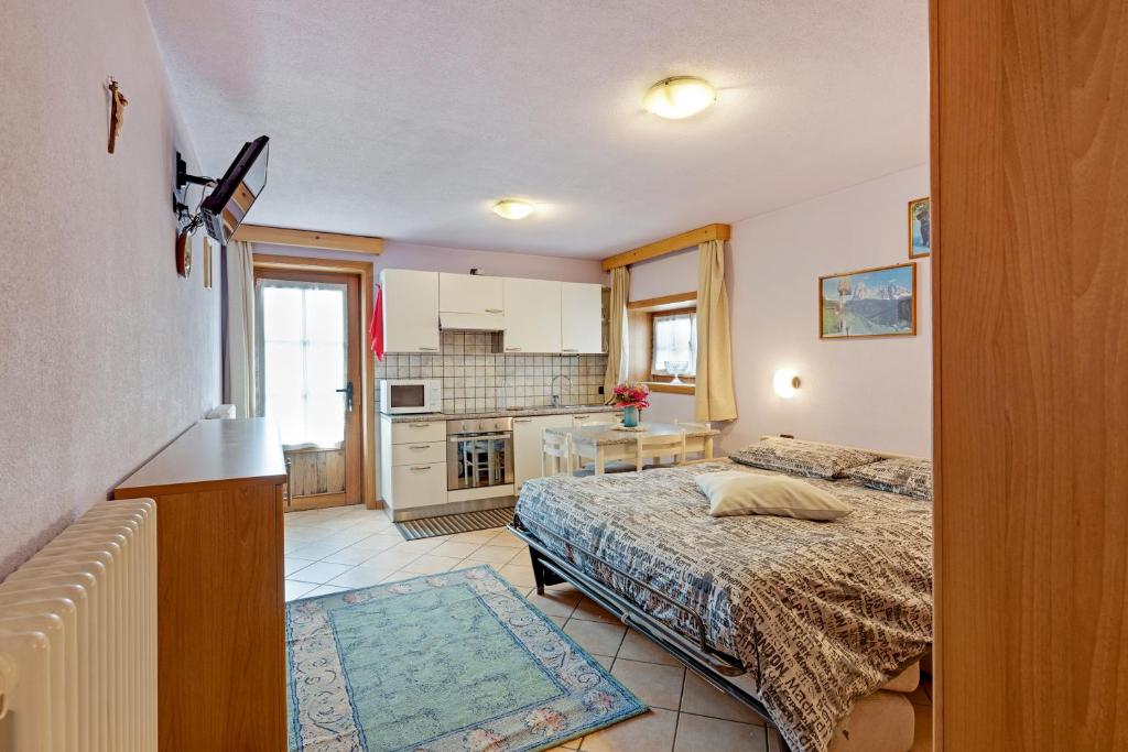 a small bedroom with a bed and a kitchen at Orsa Minore in Livigno