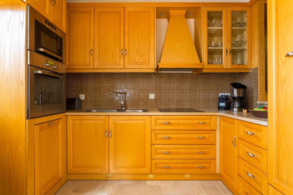 a kitchen with wooden cabinets and a sink at Flash House in Spetses