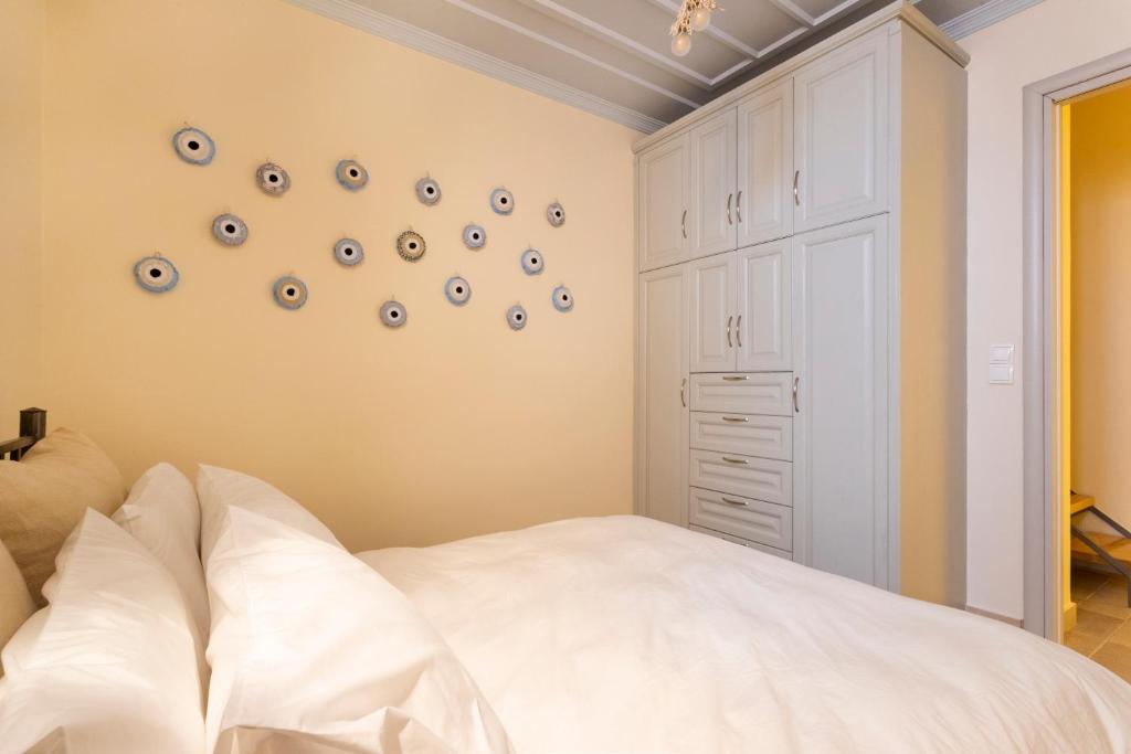 a bedroom with a white bed and some plates on the wall at Flash House in Spetses