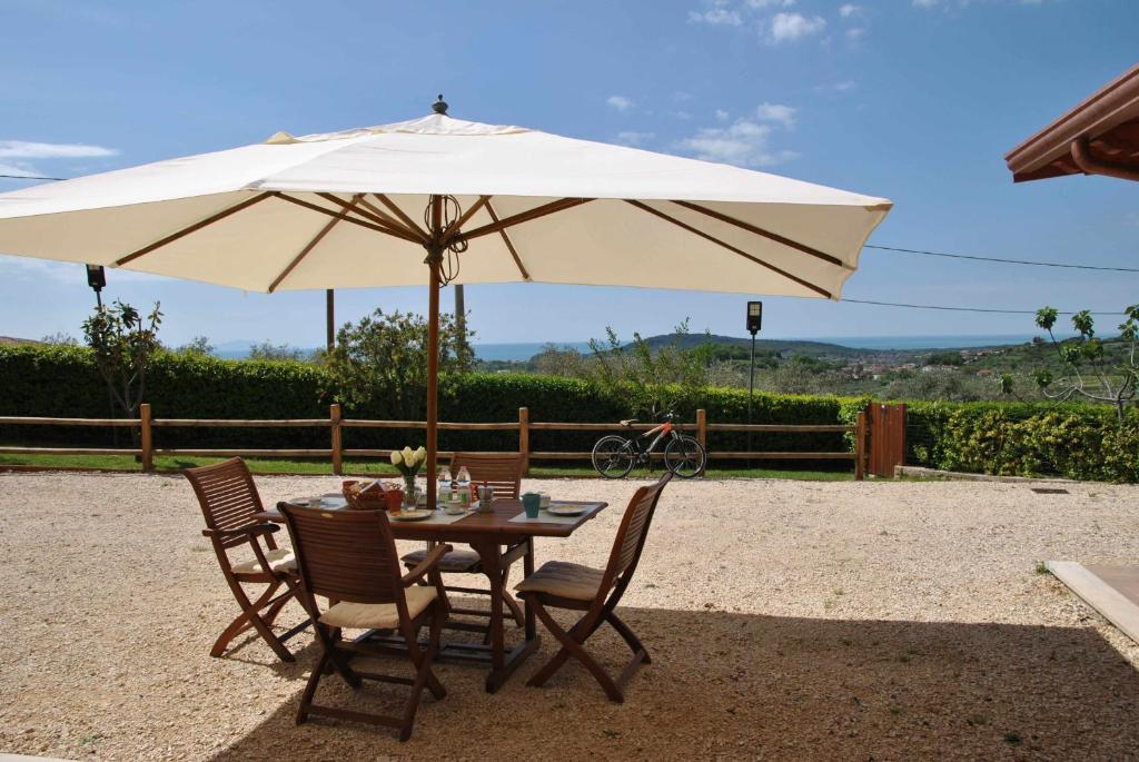 uma mesa e cadeiras com um grande guarda-sol em PICCOLO PARADISO vista mare in collina em Formia