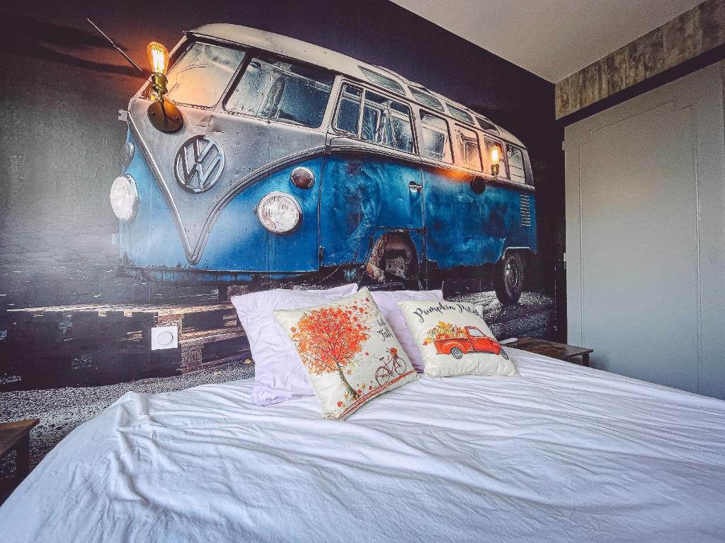 a bedroom with a bed with a painting of a van at Kombi By Carl-Emilie in Épinal