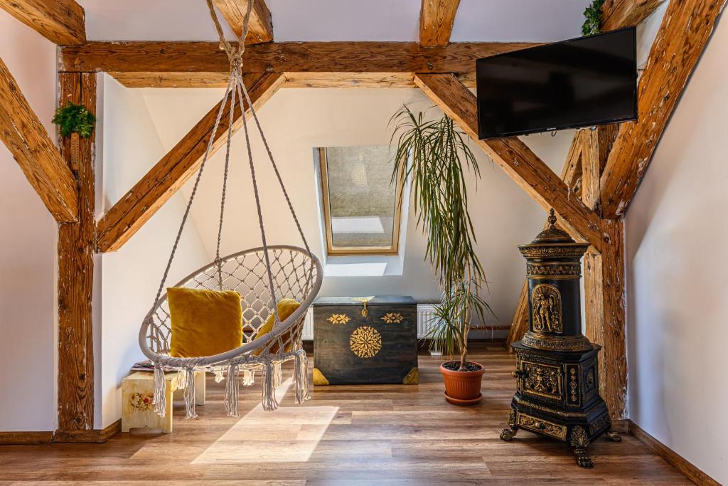 uma sala de estar com uma televisão e uma cadeira em Historical GuestHouse em Brasov