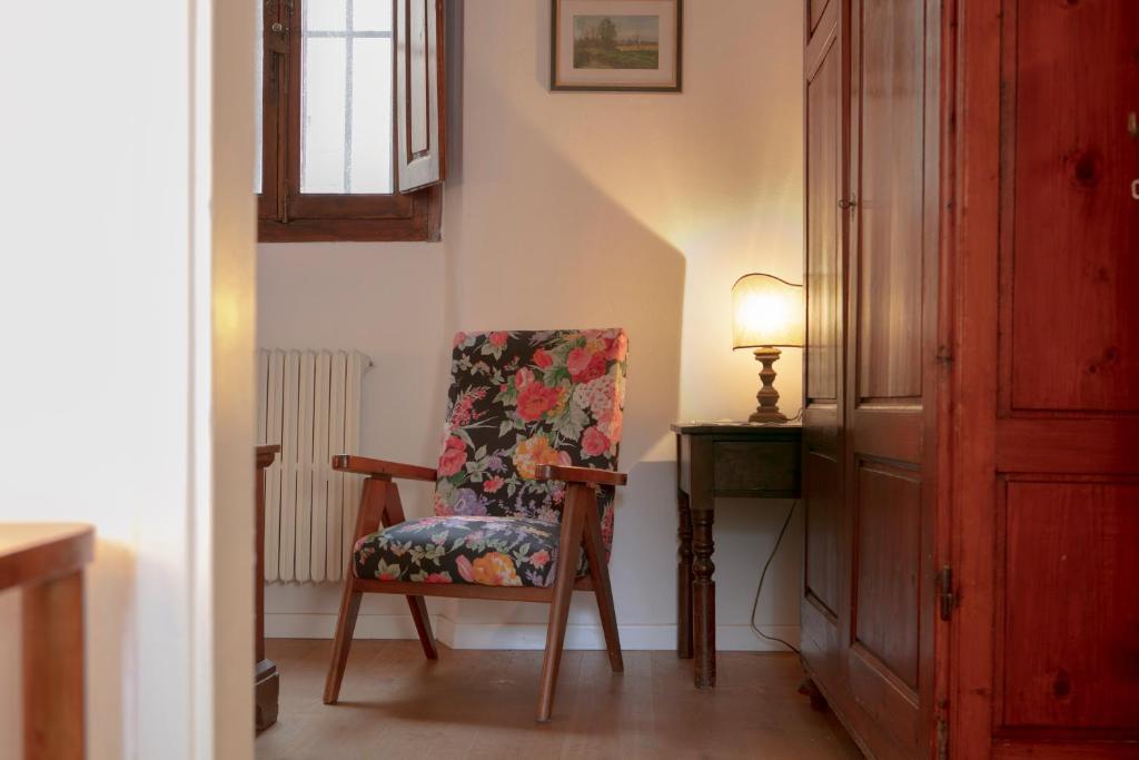 krzesło siedzące w pokoju z lampką w obiekcie Roommo Viuzzo delle Canne we Florencji