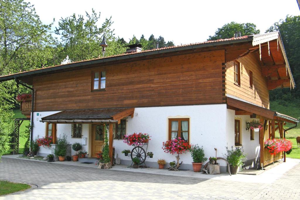 ein großes Holzhaus mit Blumen davor in der Unterkunft Ferienwohnungen Wanderparadies in Aschau im Chiemgau