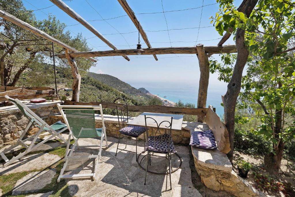 d'une terrasse avec des chaises et une table et une vue sur l'océan. dans l'établissement appartamento ulivo, à Finale Ligure