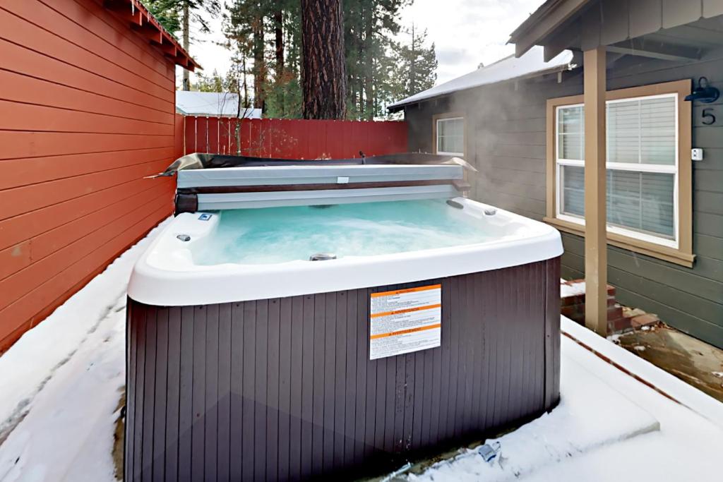a hot tub in the snow next to a house at Manzanita Holiday 2 in South Lake Tahoe