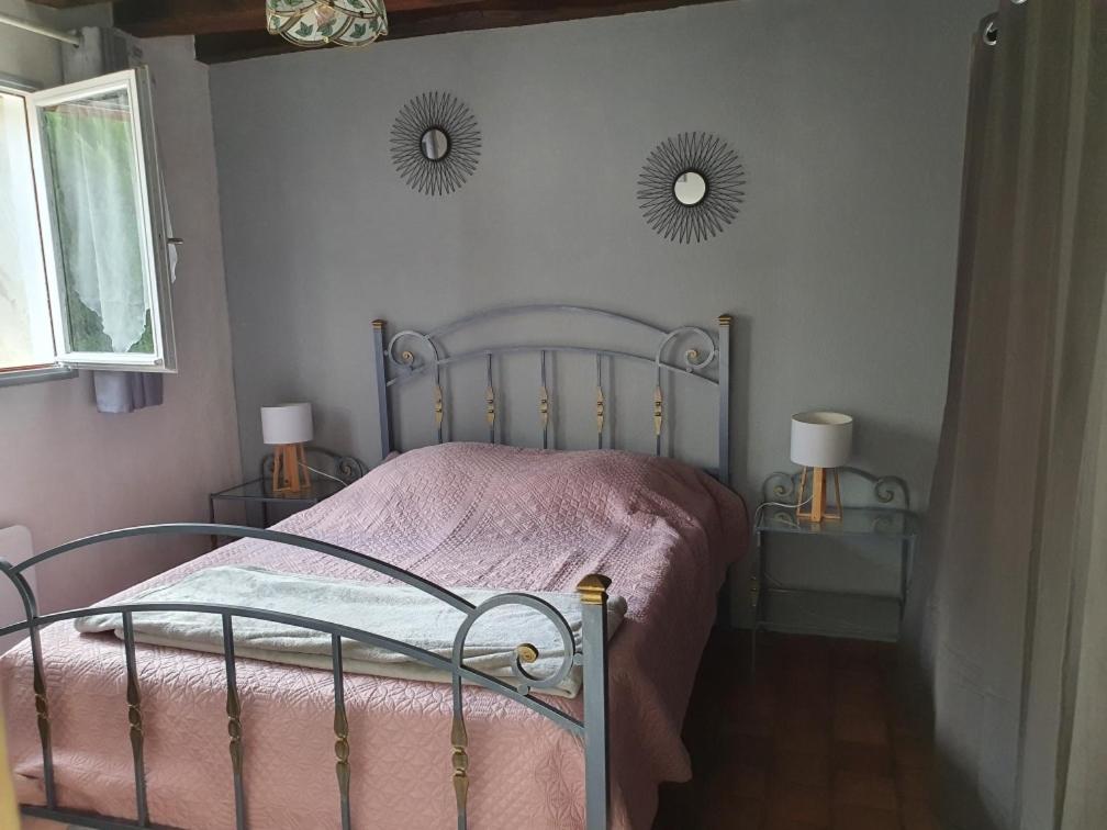 a bedroom with a bed and two mirrors on the wall at Gite les Bruyères in Salbris