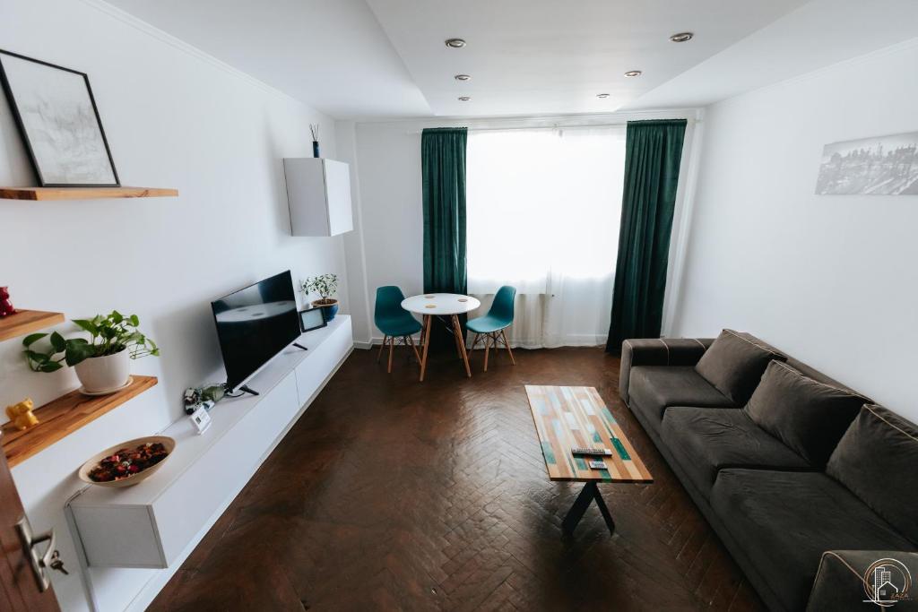 a living room with a couch and a table at ZAZA Apartament - central area, with balcony in Târgu Jiu