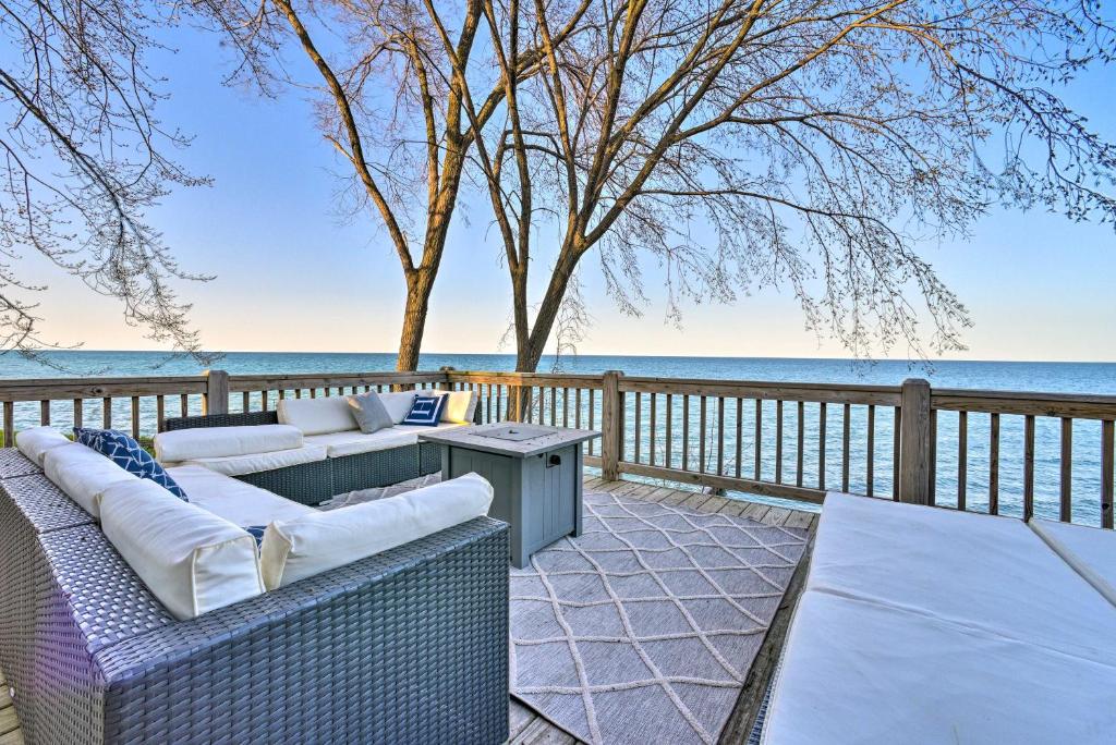 eine Terrasse mit 2 Sofas, einem Tisch und Meerblick in der Unterkunft Lakefront Lexington Escape Steps to Beach! in Lexington