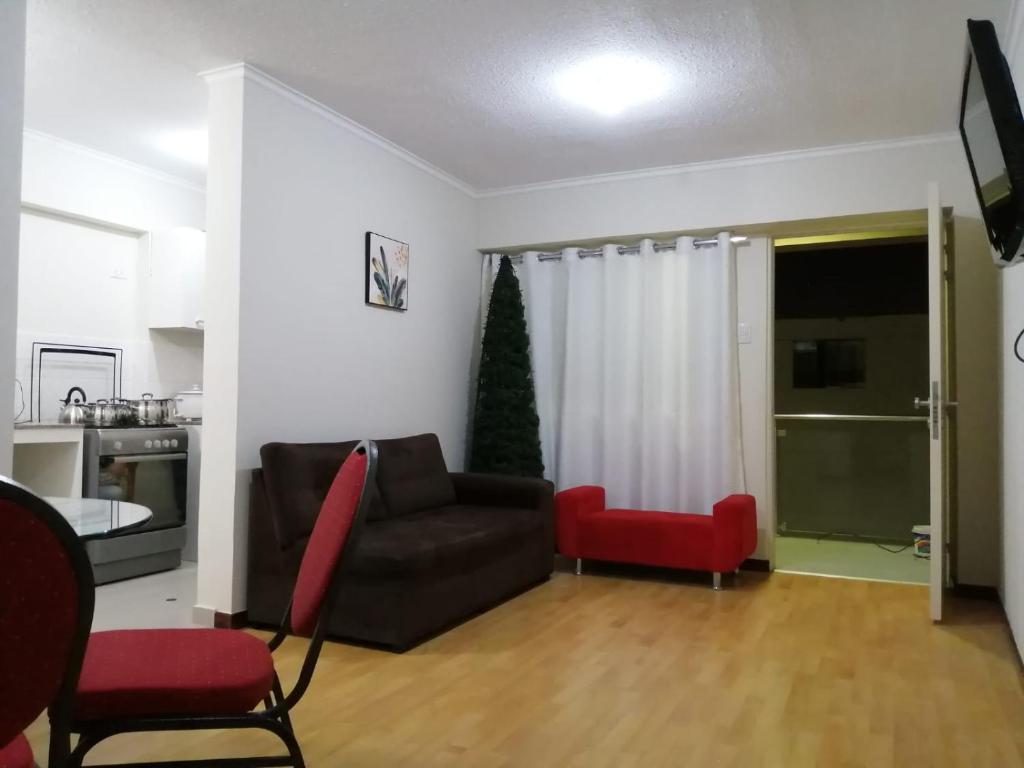 a living room with a couch and a red chair at YLLARICH in Trujillo