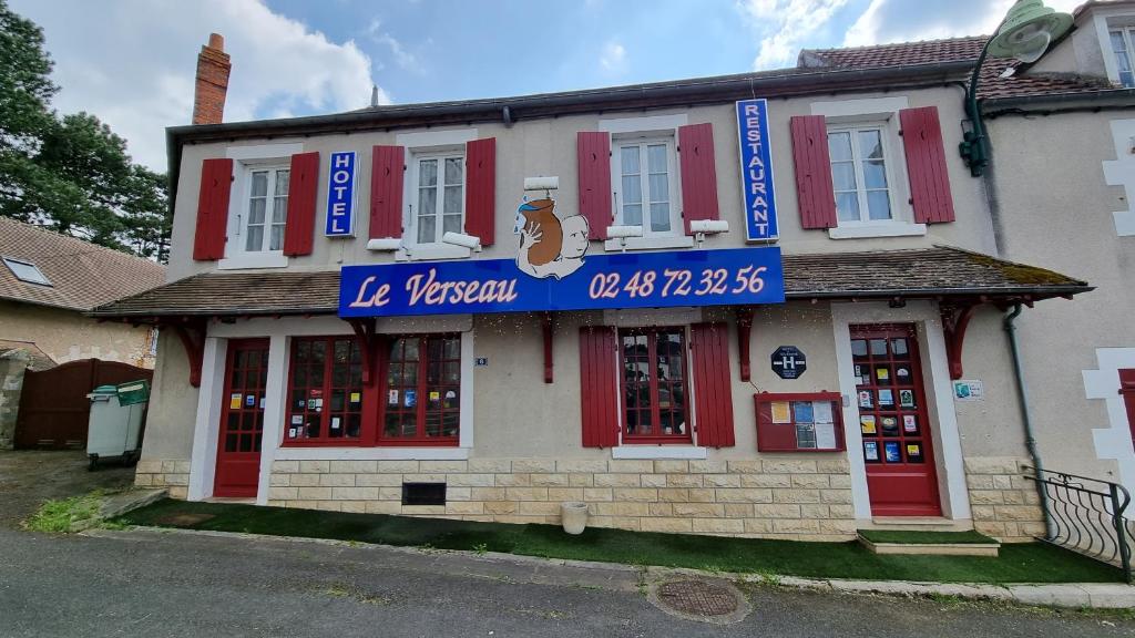a building with red doors and a blue sign on it at Hôtel Le Verseau in Boulleret
