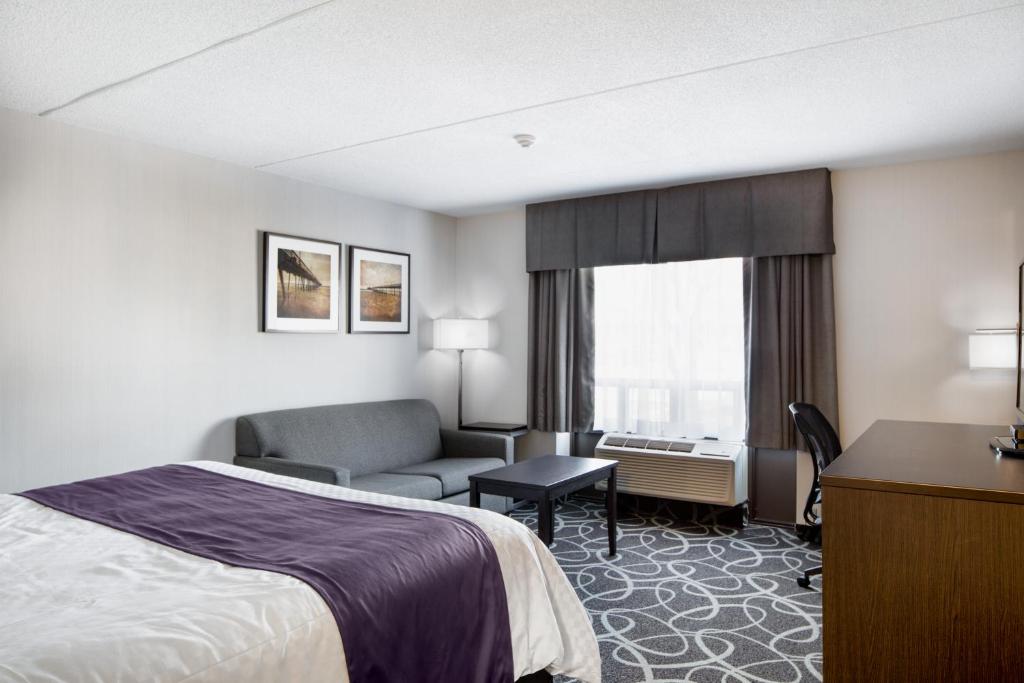 a hotel room with a bed and a chair at Stonecroft Inn in Windsor