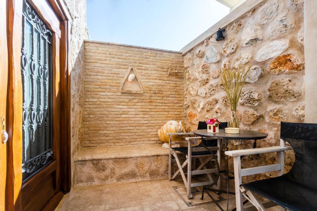a room with a table and a stone wall at Flash House in Spetses