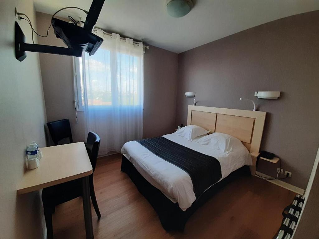 1 dormitorio con cama, mesa y escritorio en Hôtellerie Saint Jean en Saint-Jean-de-Thouars