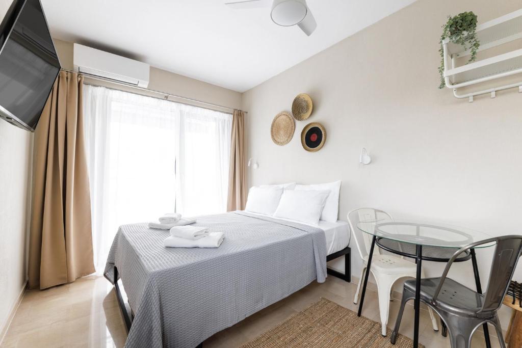 塞薩羅尼基的住宿－Boho Rooms，一间卧室配有一张床、一张桌子和一台电视。