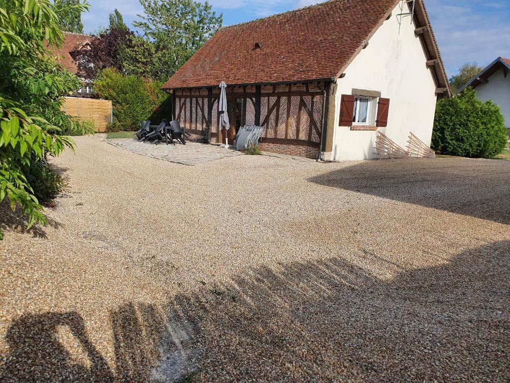 a house with a shadow on the ground at Gite les Bruyères in Salbris