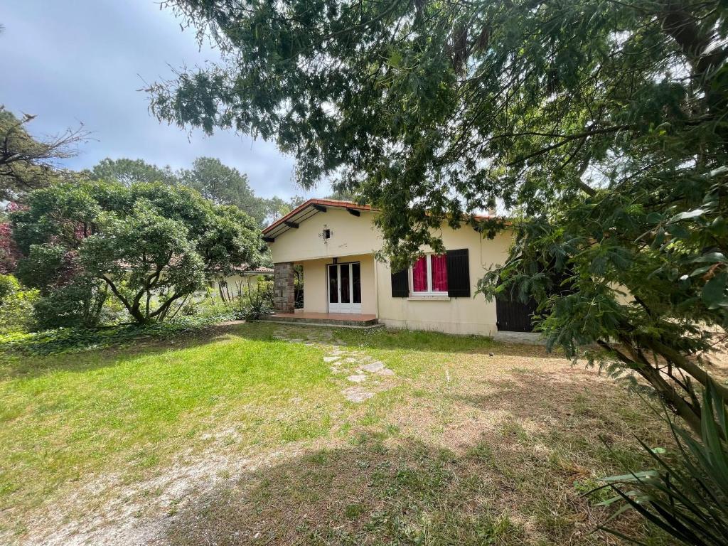 une petite maison blanche avec une cour dans l'établissement Villa MarieAnne, à Mimizan