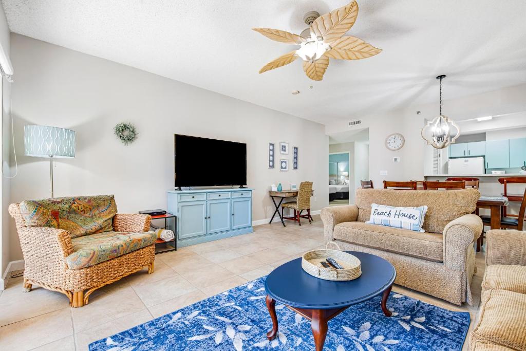 a living room with furniture and a flat screen tv at TOPS'L Summit 210 in Destin