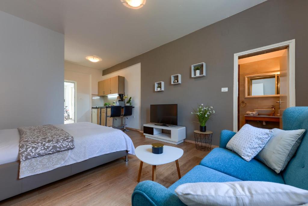 1 dormitorio con cama, sofá y TV en Sara Residence en Zadar