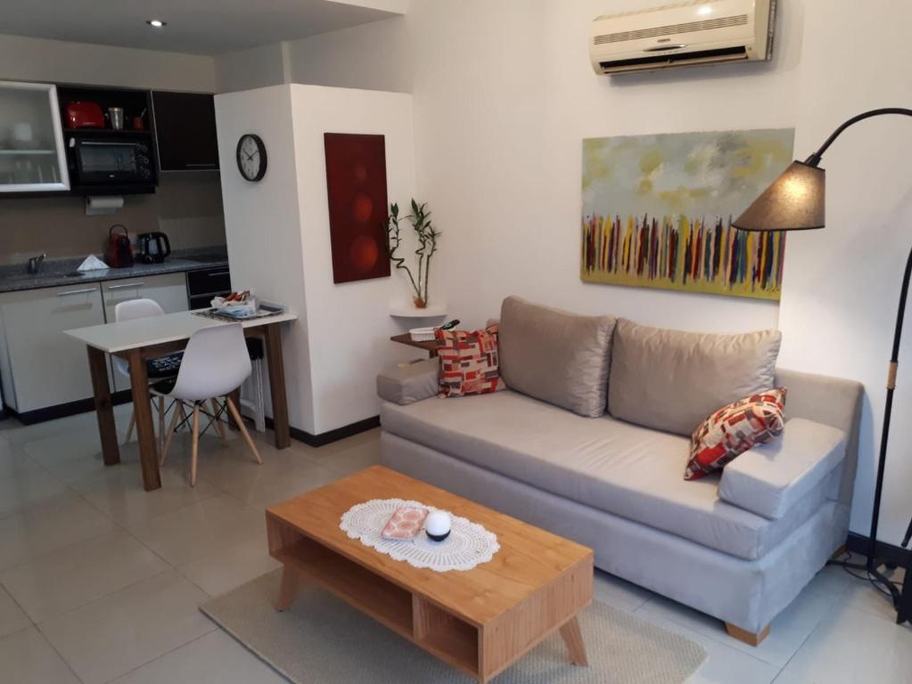ein Wohnzimmer mit einem Sofa und einem Tisch in der Unterkunft Gurruchaga Suites free parking Movistar Outlet in Buenos Aires