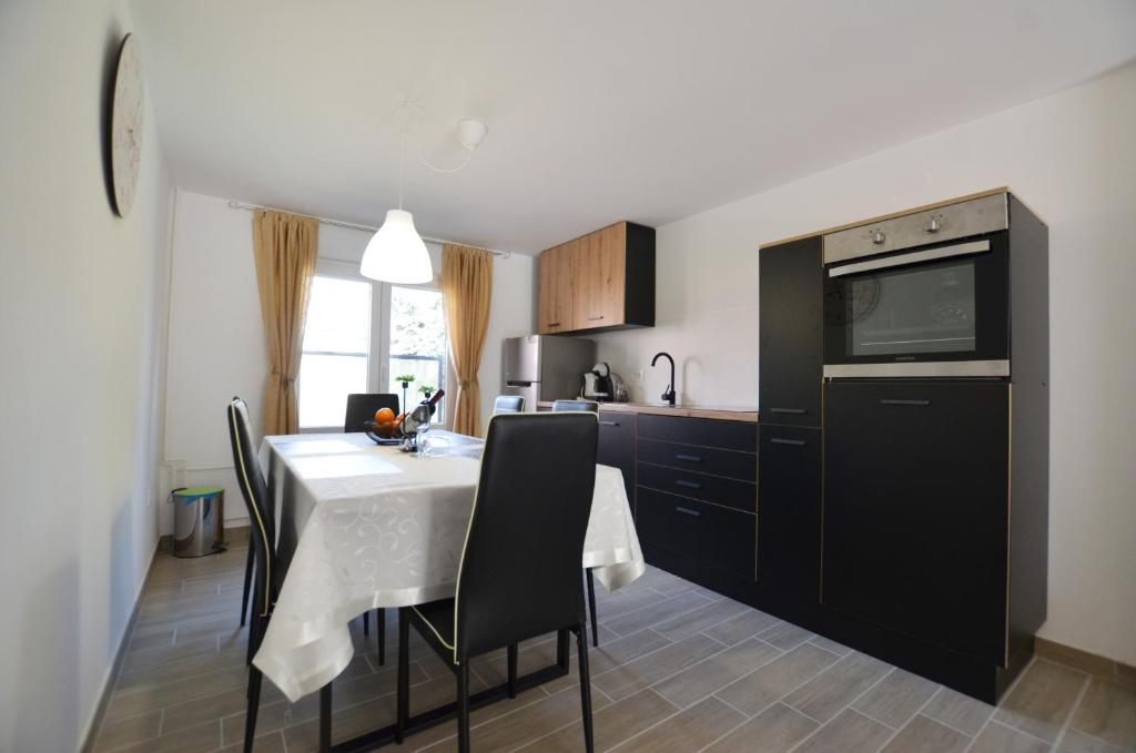 una cucina con tavolo, sedie e forno a microonde di Katy Apartment a Rovigno (Rovinj)