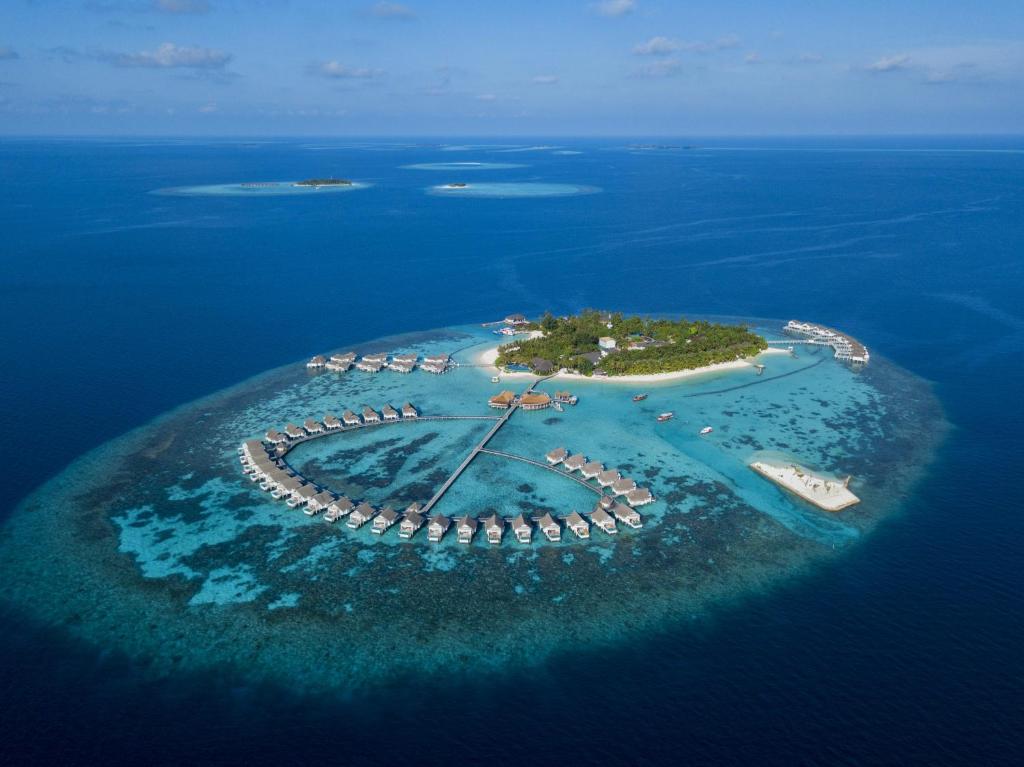 eine Insel im Ozean mit Booten im Wasser in der Unterkunft Centara Grand Island Resort & Spa in Machchafushi