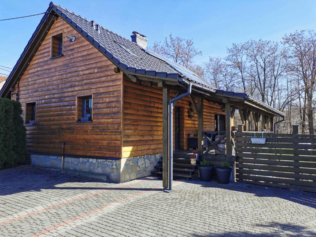 a large wooden cabin with a pitched roof at Domek Socałówka in Sułkowice