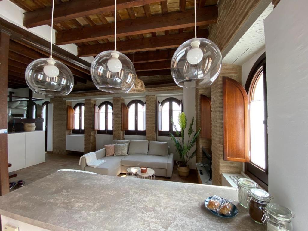 uma sala de estar com várias luzes pendentes de vidro em Hostfy Centro, Puerta Osario em Sevilha