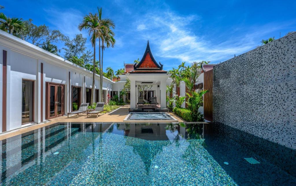 an exterior view of a villa with a swimming pool at Maikhao Dream Villa Resort and Spa, Centara Boutique Collection - SHA Extra Plus in Mai Khao Beach