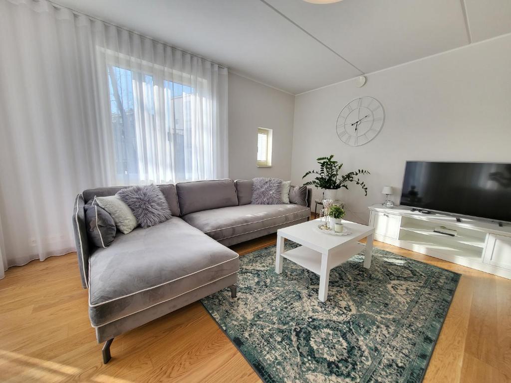 sala de estar con sofá y TV de pantalla plana en City Center Bright Home, en Tallin