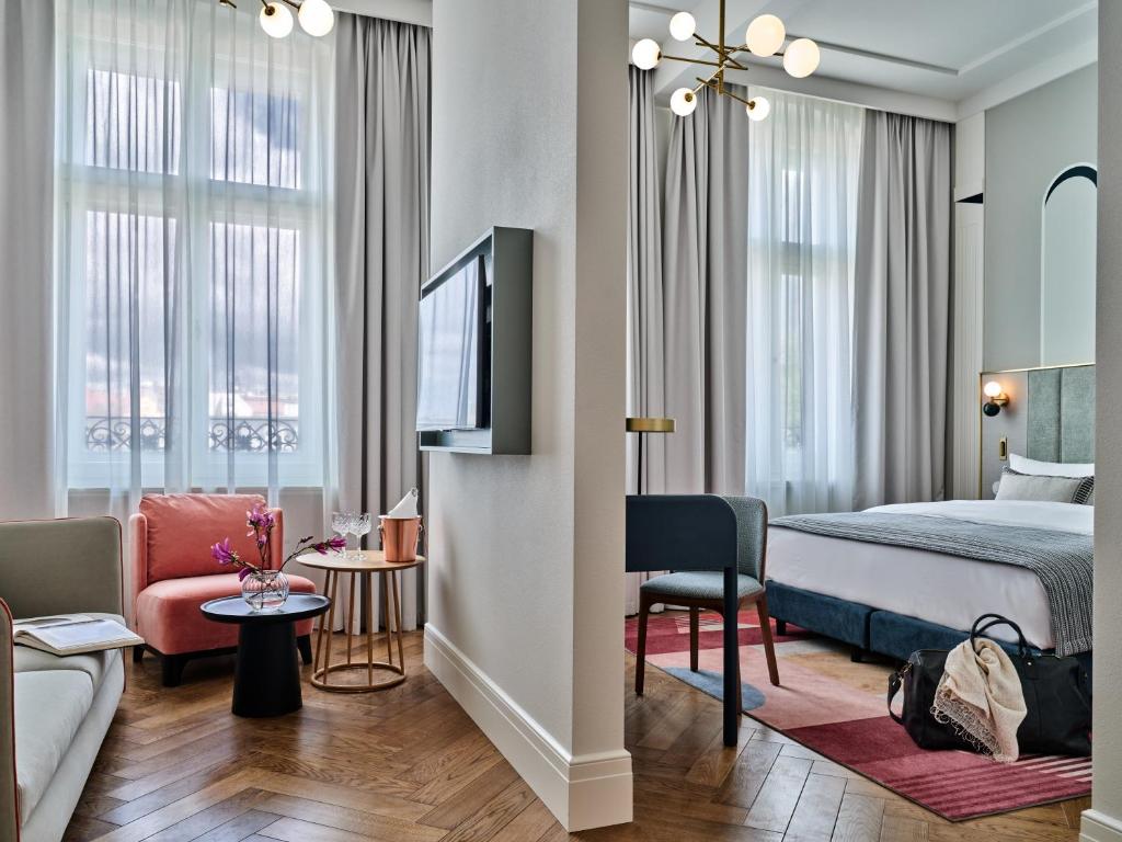 um quarto de hotel com uma cama e uma sala de estar em Hotel Altus Palace em Breslávia