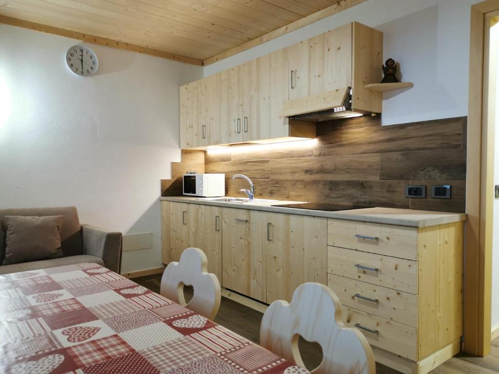 een keuken met een tafel, een wastafel en een aanrecht bij App Col di Lana - Agriturismo La Majon da Col in Colle Santa Lucia