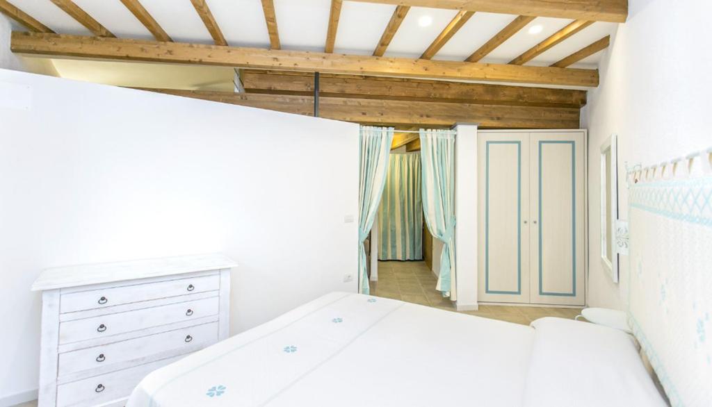 1 dormitorio blanco con 1 cama y vestidor en Ferienwohnung Chiara, en Seneghe