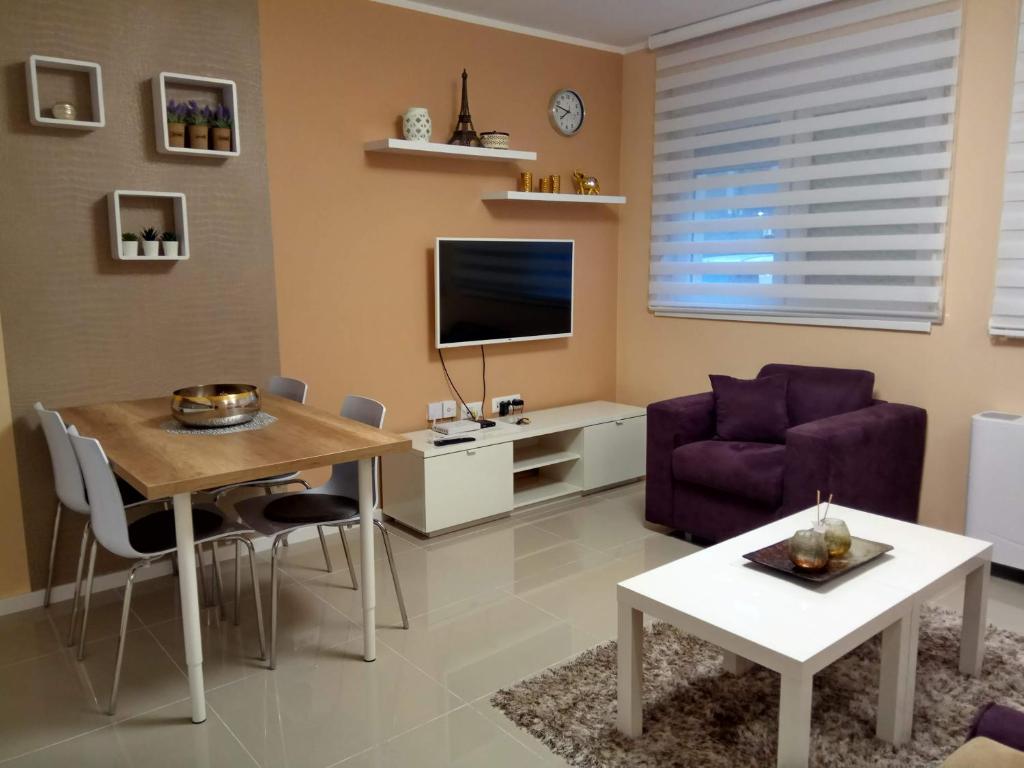 sala de estar con mesa y TV en Apartment Cherry Gold, en Zrenjanin