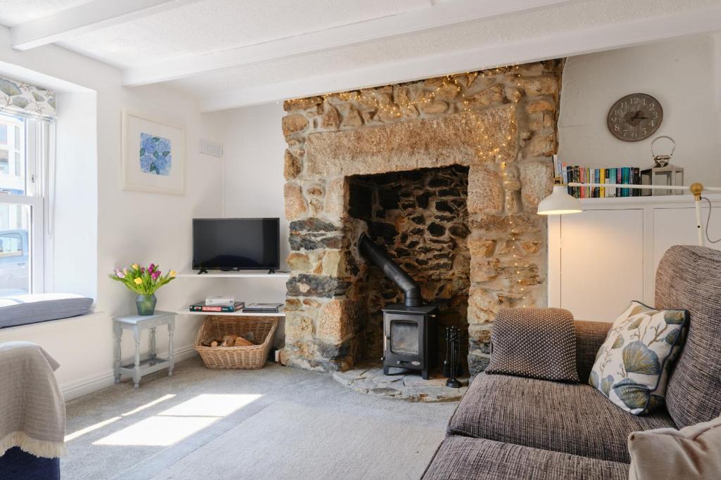 salon z kamiennym kominkiem w obiekcie Finest Retreats - Coral Cottage w mieście Porthleven