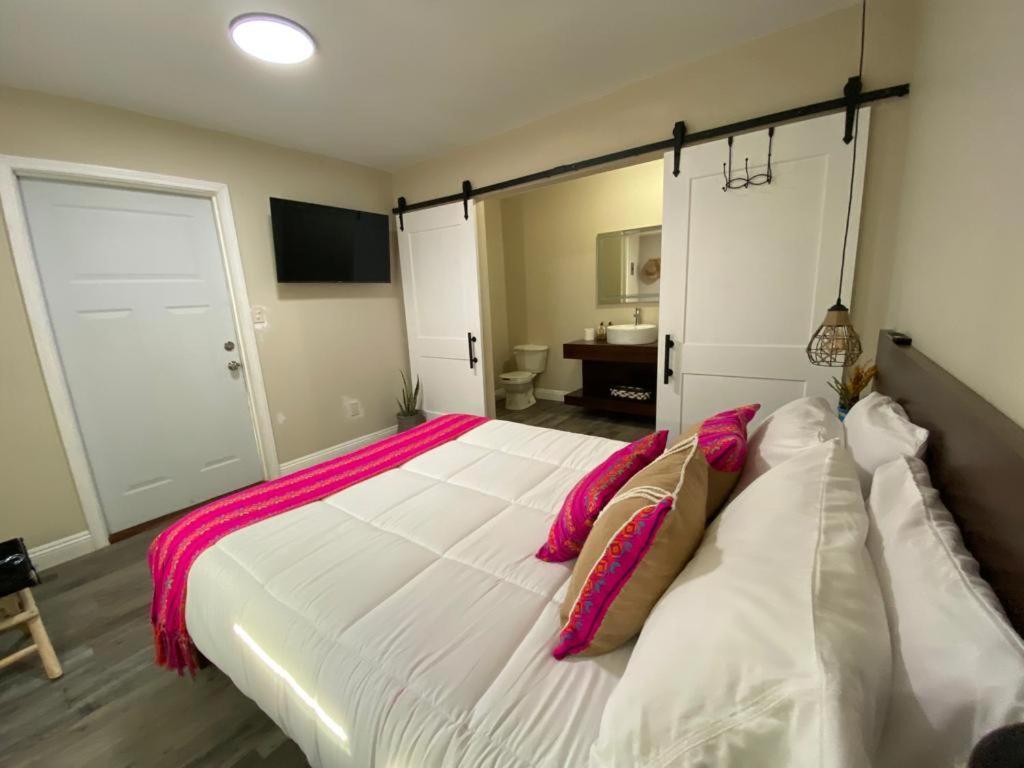 a bedroom with a large white bed with pink pillows at Cerrado in El Porvenir