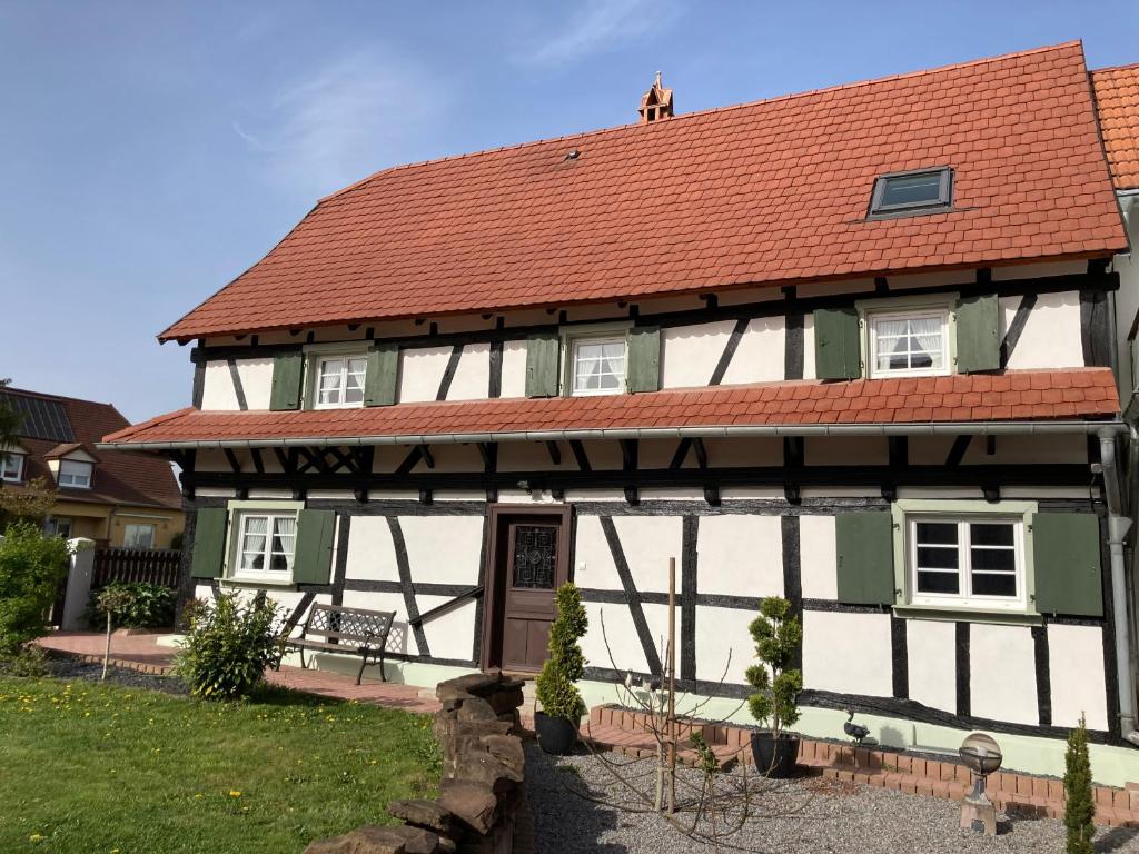 une maison avec un toit rouge et une cour dans l'établissement La clé du Temps, à Offendorf