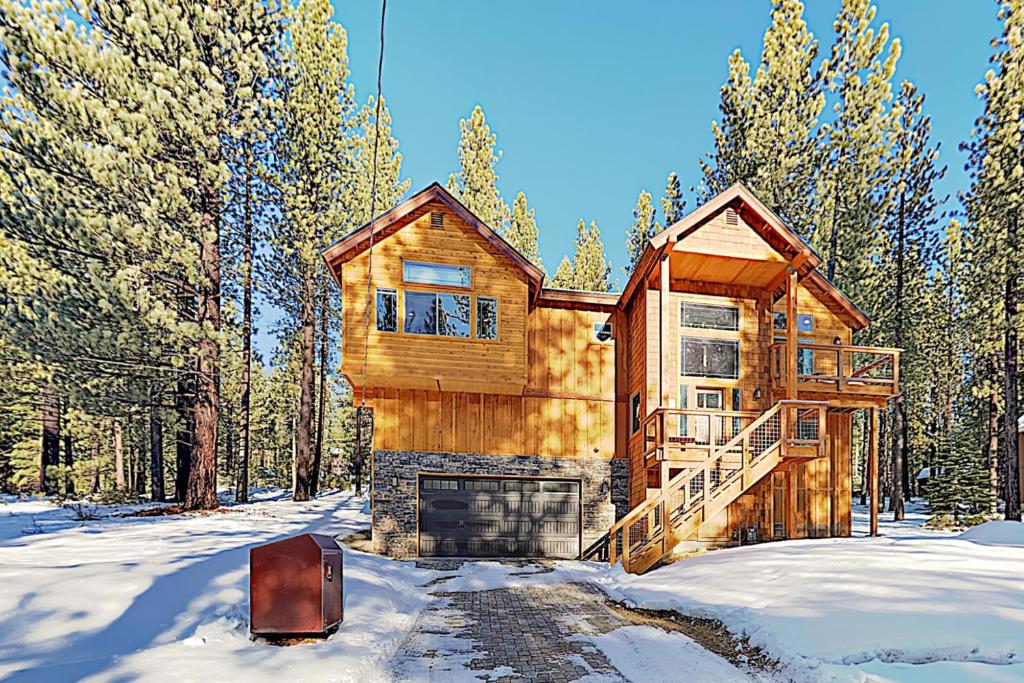 une maison en rondins dans les bois dans la neige dans l'établissement Luxury Mountain Retreat, à South Lake Tahoe