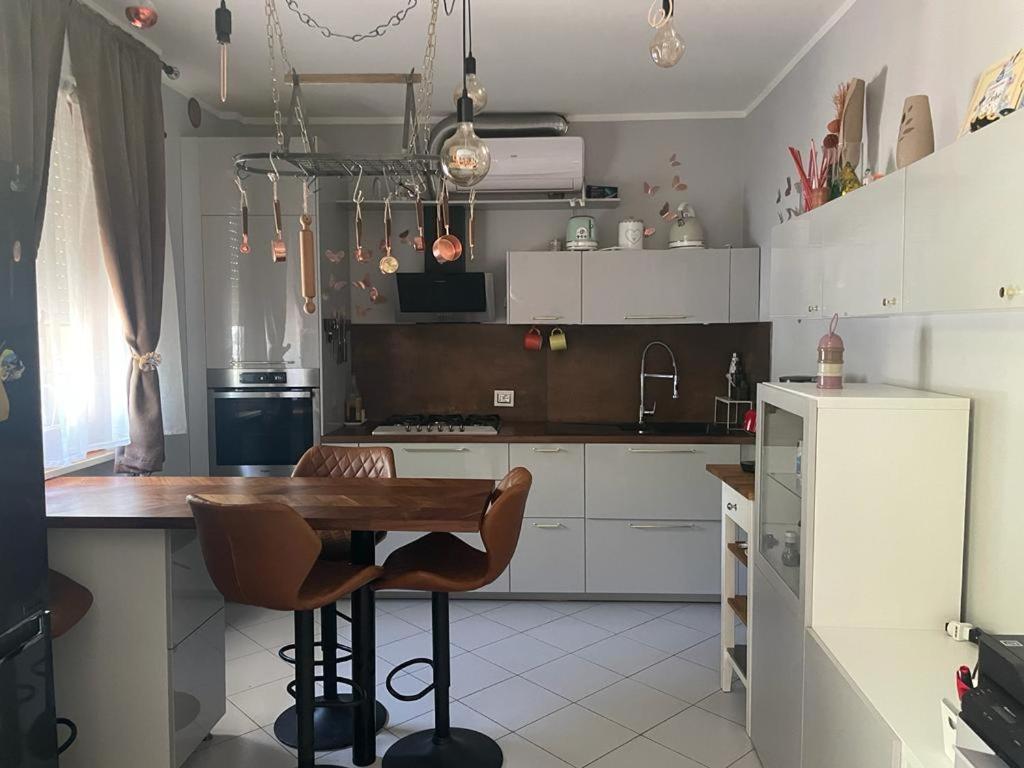 a kitchen with a wooden table and a refrigerator at WellHome in Marina di Montemarciano