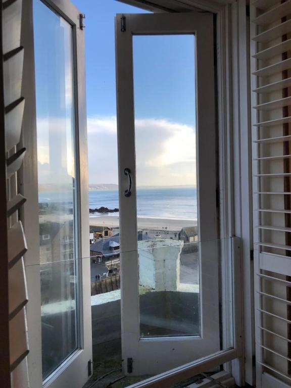 an open door with a view of the ocean at Harbour House Looe in Looe