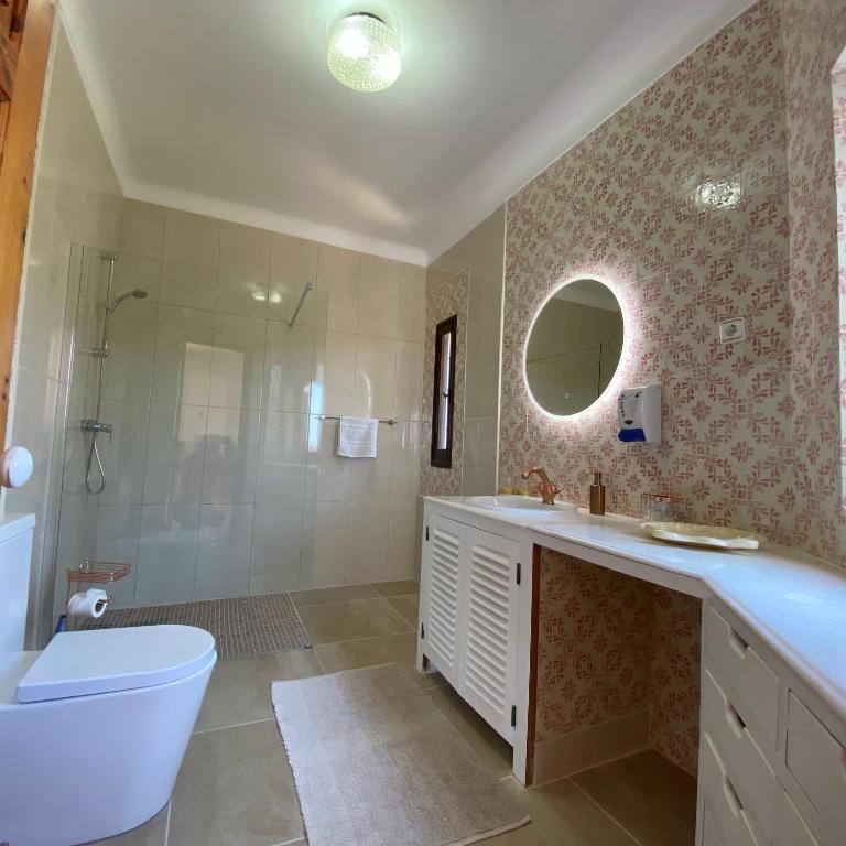 a bathroom with a tub and a toilet and a sink at Casa do Milho in Carvoeiro