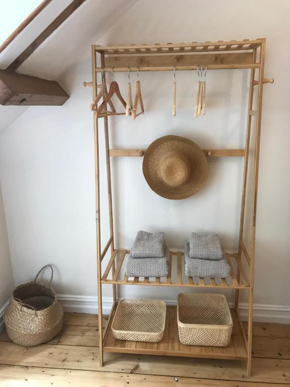 a shelf with baskets and a hat on a wall at Harbour House Looe in Looe