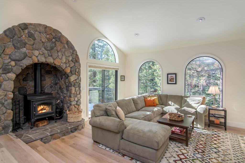 Una sala de estar con un sofá y una chimenea. en Schussing Paradise, en Truckee