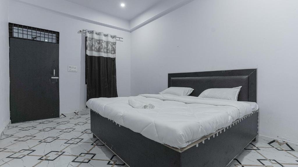 阿格拉的住宿－Kaka Ji Palace By WB Inn，一间卧室配有一张大床和黑色床头板