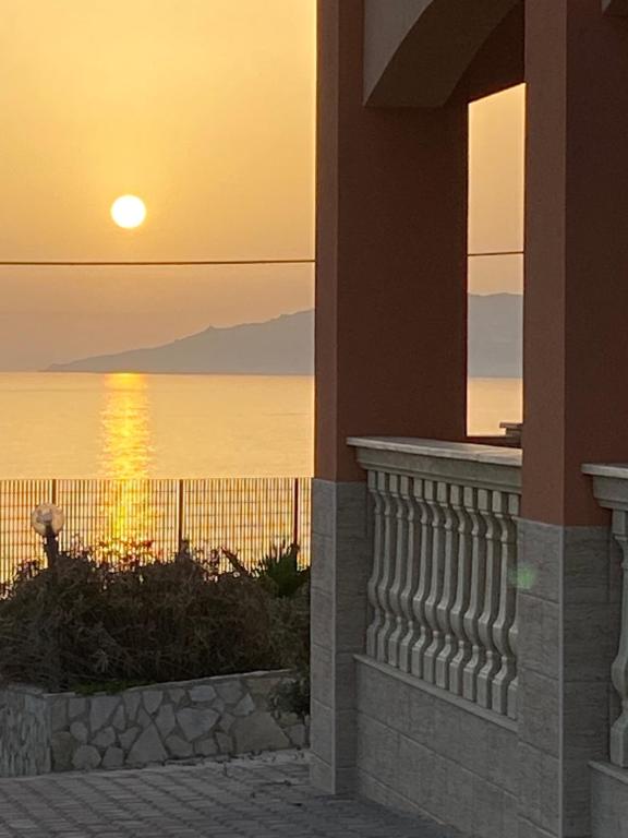 a sunset from a building with a view of the ocean at Carrubella Santa Zita in Licata