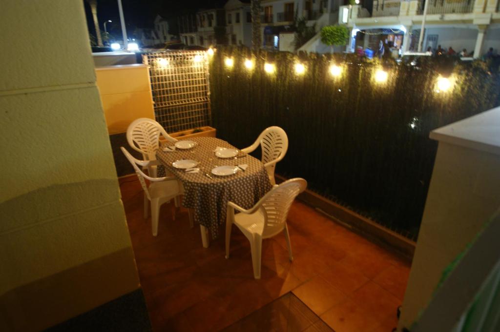 een tafel en stoelen op een balkon met verlichting bij Apartamento en Vera a 300 m de la playa, con patio y salida directa a calle in Vera