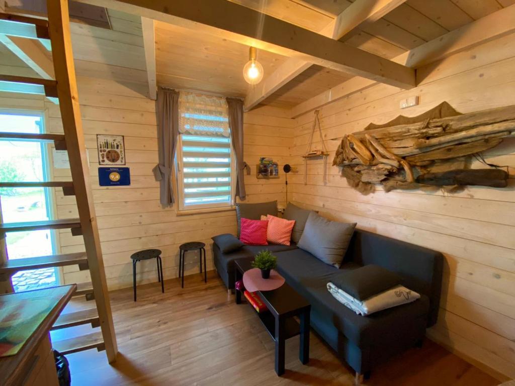 ein Wohnzimmer mit einem blauen Sofa in einer Hütte in der Unterkunft Brzozowy Gaj in Bachowice