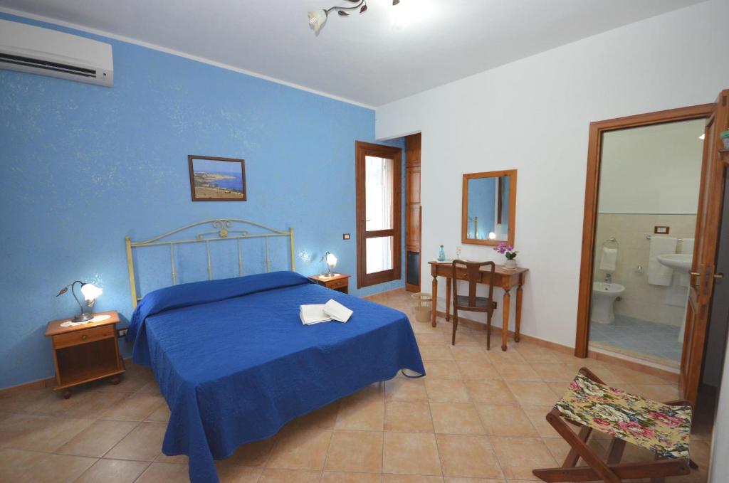 a blue bedroom with a bed and a bathroom at Cascina degli Ulivi in Castelluzzo